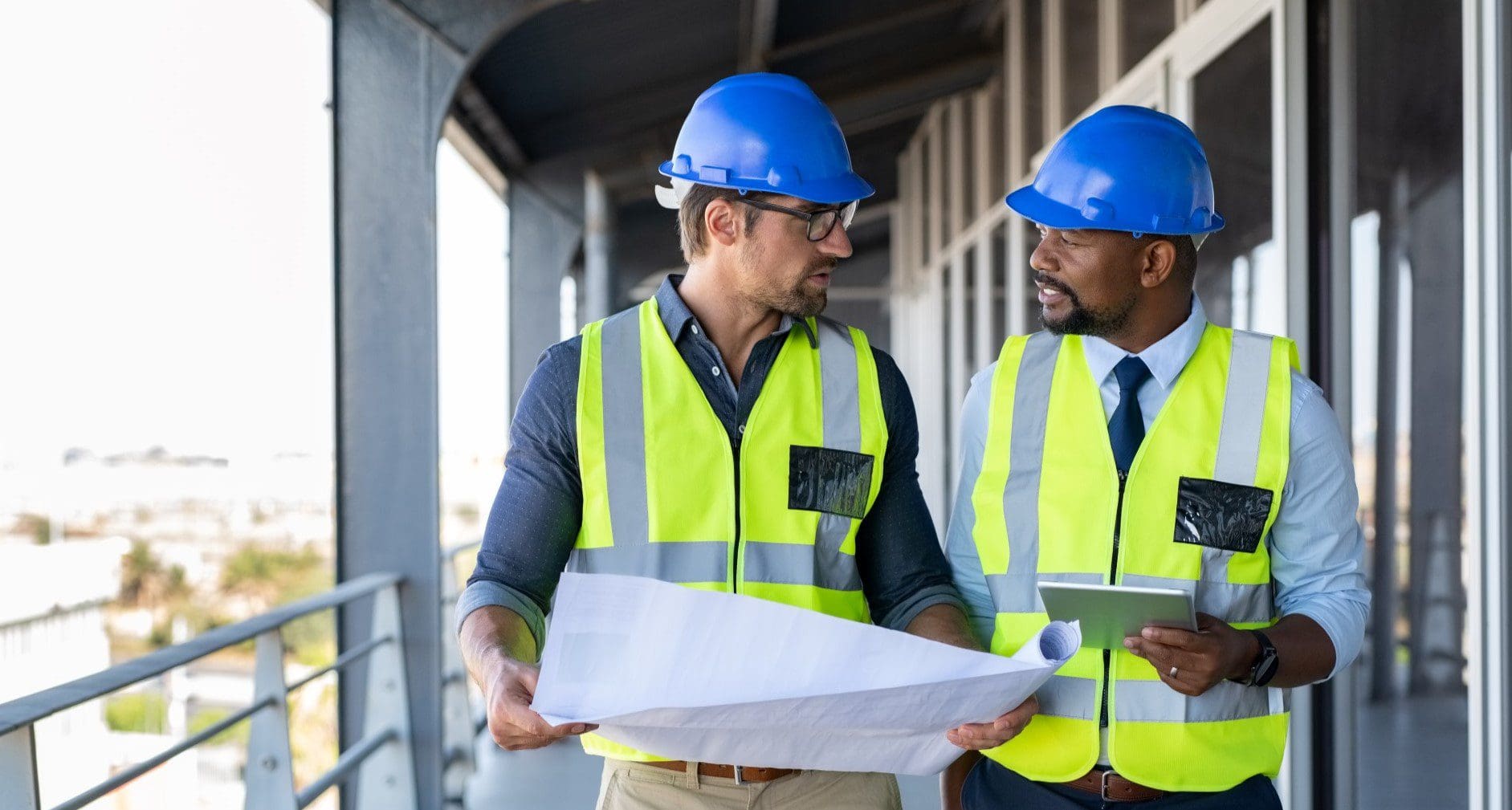 Two men in hard hats collaborating